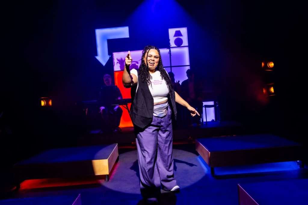 Susan stands centre stage trying awkwardly to look cool