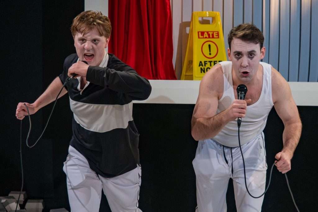 Oliver Maynard and Nick Hyde mime running with determined expressions